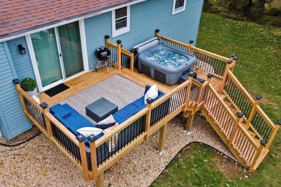 Deck, hot tub, furniture, charcoal grill, fire pit, and games highlight our large back yard.