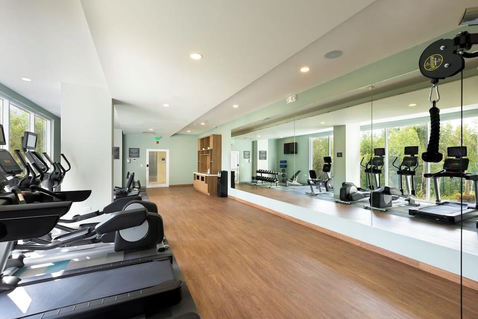 Recharge with cardio and strength training in airy mirrored gym.