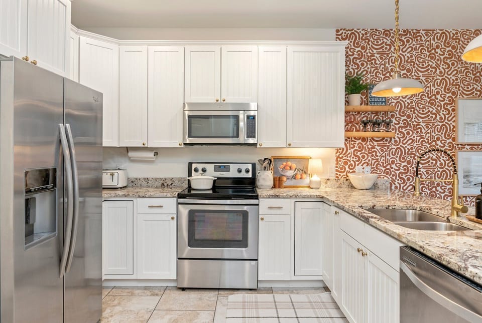 Equipped with a full-sized dishwasher, stove, and refrigerator.