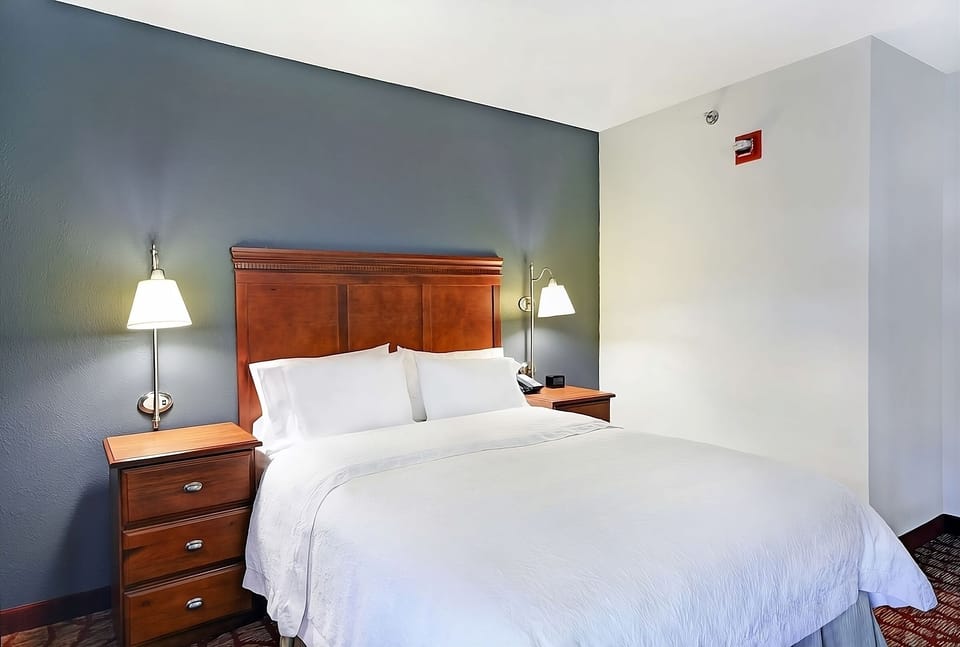 Drift off easily in a cozy king bed with bedside lamps.