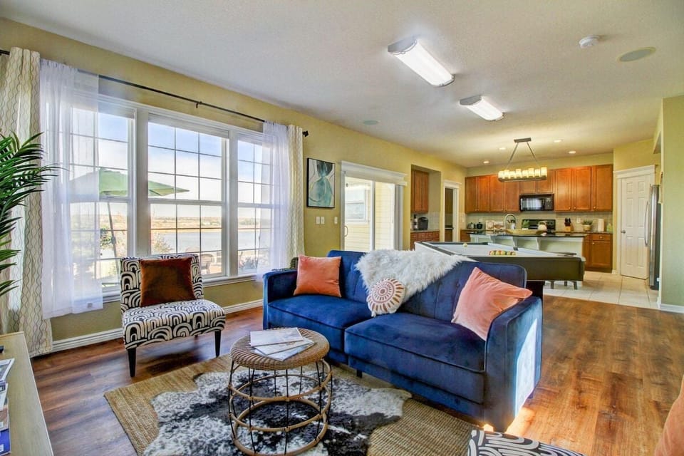 Cozy relaxation awaits in this living room, featuring a plush couch perfect for unwinding. The large window frames tranquil lake views, inviting serenity into the space.