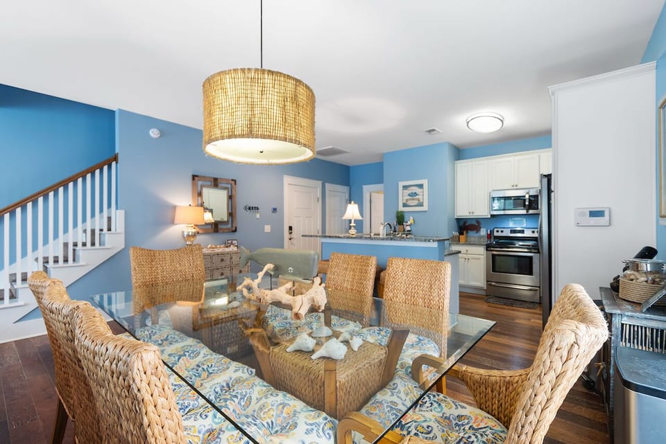 Unwind in your bright coastal dining space with woven chairs and a stunning pendant light overhead.