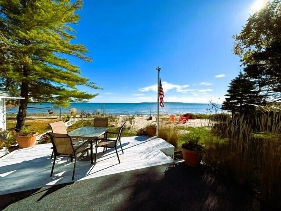 Original waterfront deck off master bedroom with seating overlooking Mackinac Island - Picture taken prior to newly constructed summer 2025