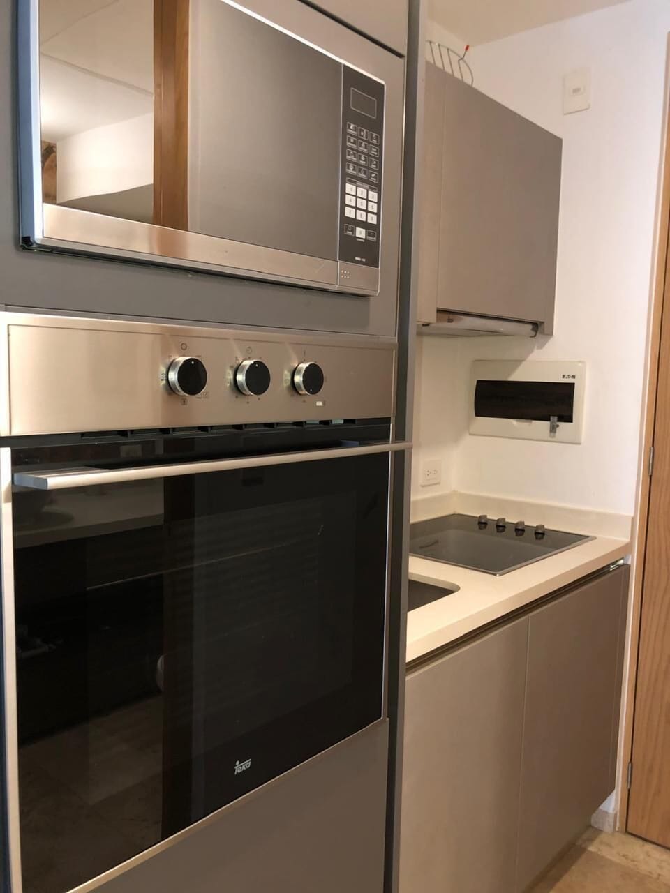 Sleek kitchen with built-in oven, microwave, and stovetop for cooking convenience