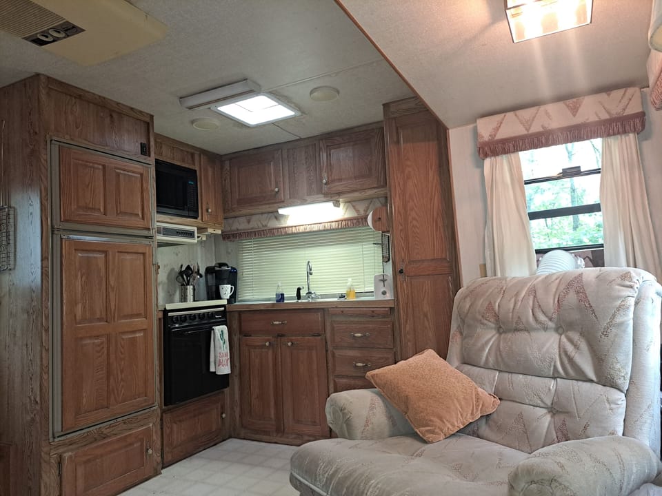 living room kitchen area,  newer fridge n range plus a water cooler.