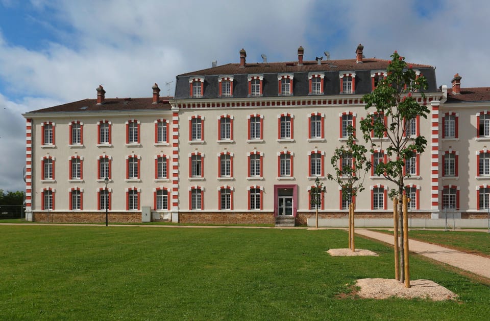 Step back in time with the charming architecture of this historic building, perfectly set against a vibrant green lawn.