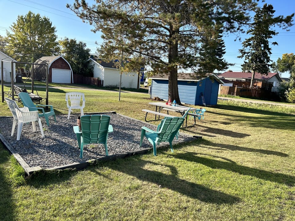 Spacious backyard with fire pit, picnic table and gas bbq. 