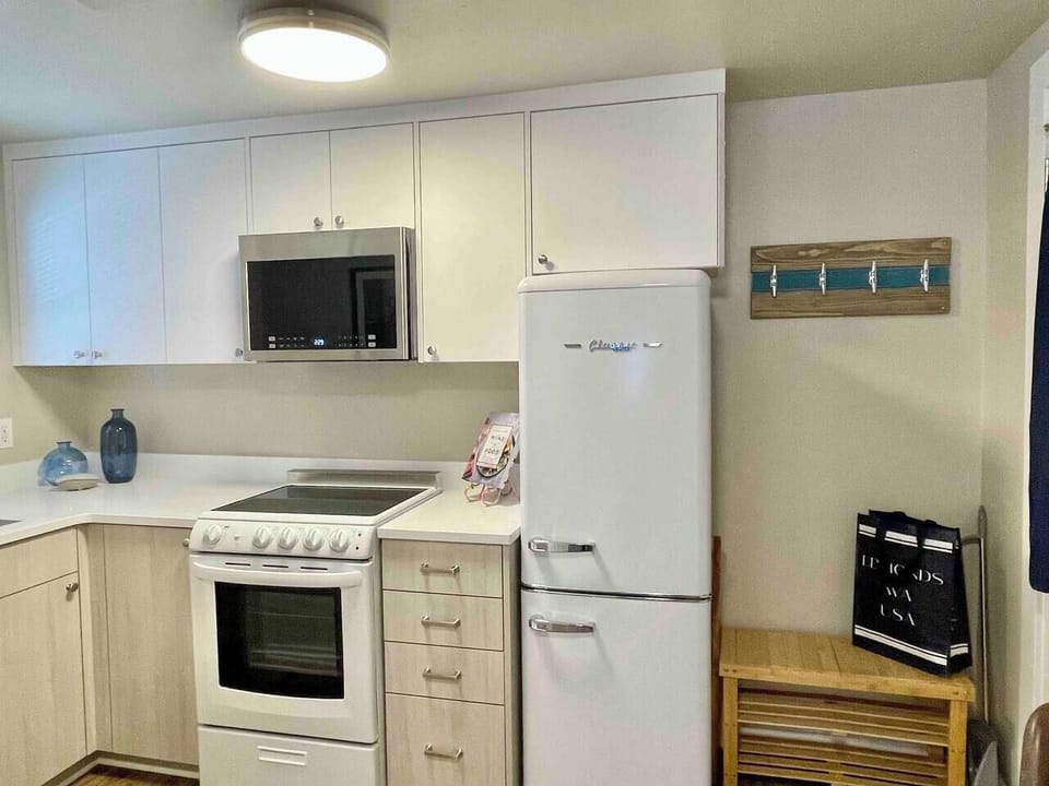 Kitchen with dishwasher, stove, refrigerator (don't you love it?!), microwave, and all the essentials! You'll find appliances and cooking utensils, fully stocked spices and oils, and coffee and tea to get you started!