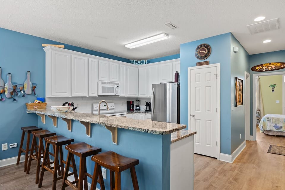 Your coastal-themed kitchen awaits with granite countertops, modern appliances, and a breakfast bar perfect for morning coffee.