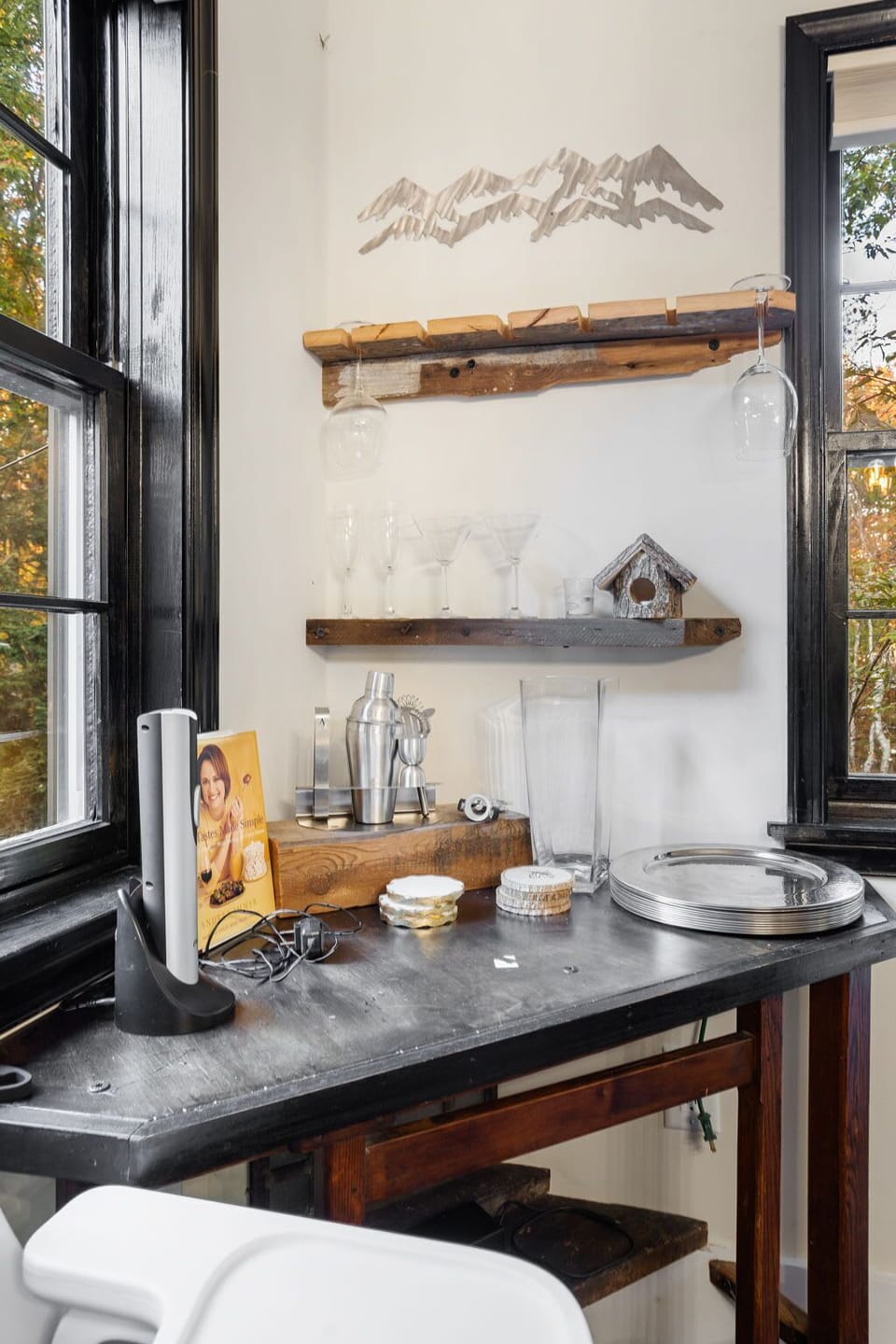 Stylish dark bar area with floating wood shelf and curated bottle display