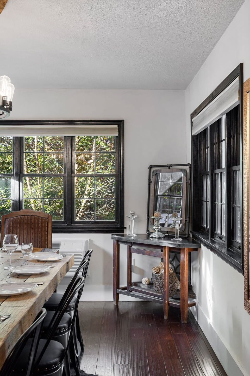 Compact bar or workspace corner with dark walls and framed forest window view