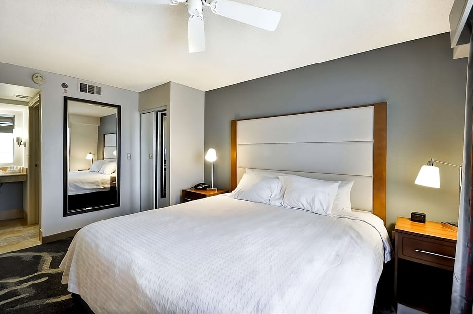 Drift off in a serene king bed with warm bedside lighting.