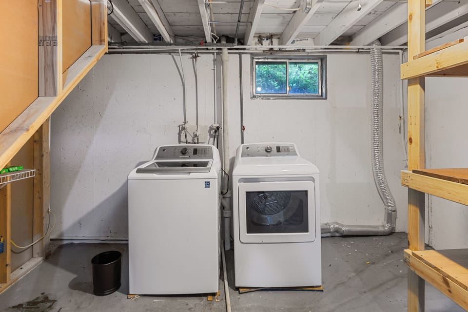 Private basement laundry area with a full-size washer and dryer for guest use.