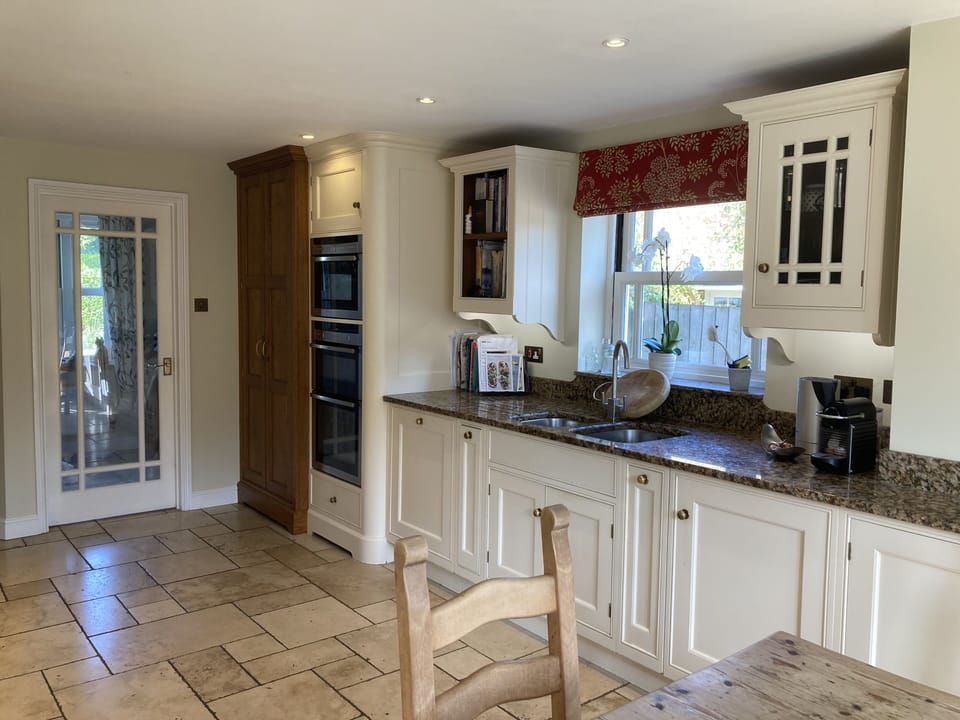 Kitchen with larder, wall oven and microwave, double sink, and nespresso