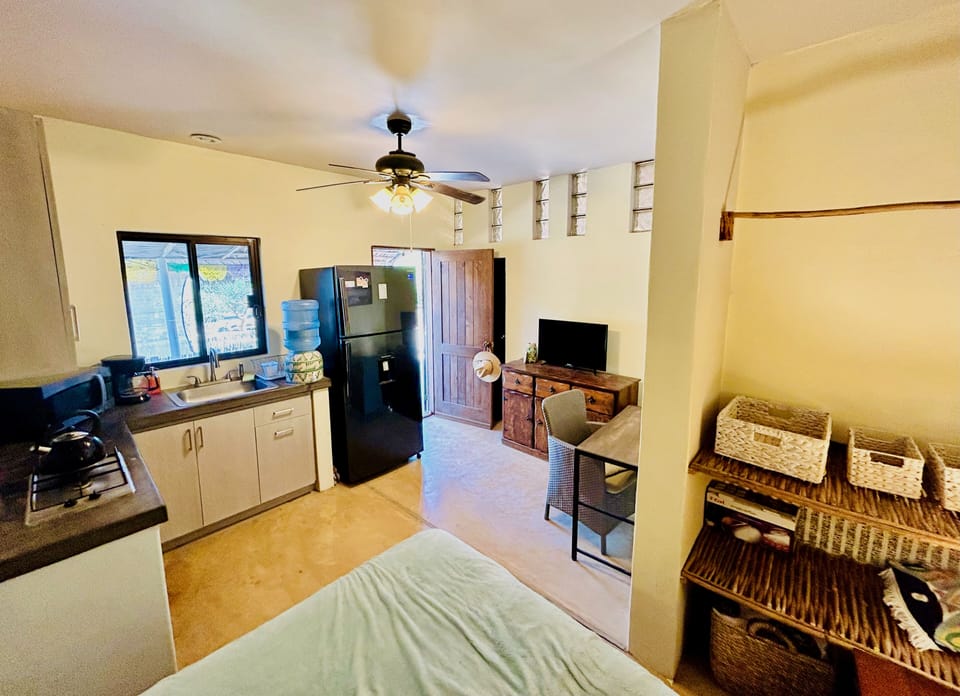 Kitchenette with full fridge with freezer, open closet area for clothes