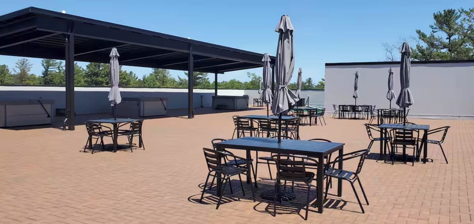 A sun-soaked rooftop retreat with open space to relax, dine, and unwind—featuring shaded lounge areas, cozy seating, and a calm, airy atmosphere perfect for enjoying fresh air and quiet moments.