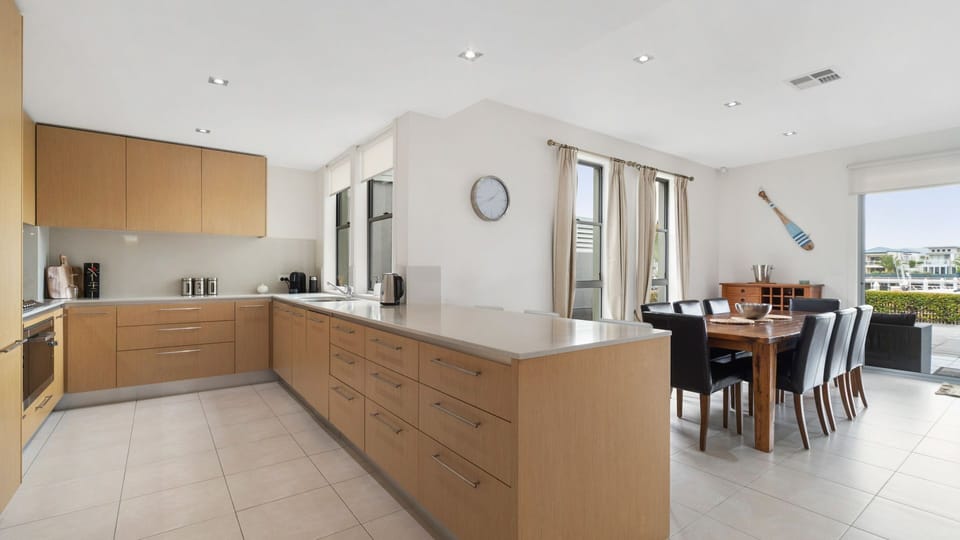 Large kitchen equipped with gas cooktop and oven and kitchen bench with seating