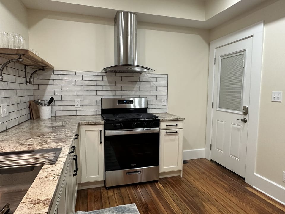 Door to a shared outdoor space and extra trash pale area.