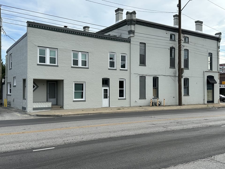 The main entrance is in the left corner of the building shown in the photo