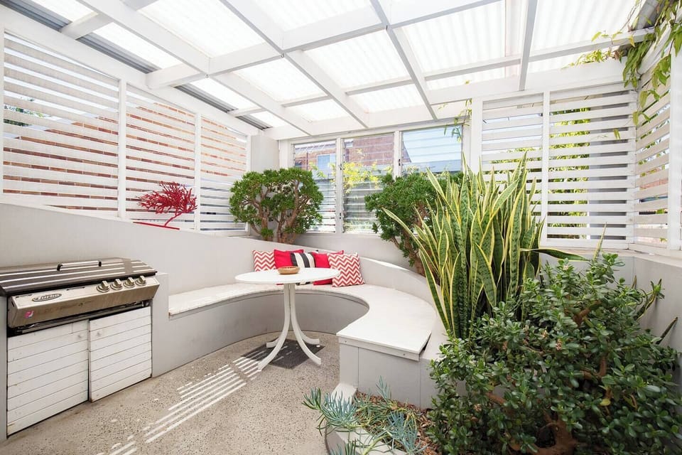 The undercover patio area has a built-in curved bench, offering space to enjoy a meal whipped up on the barbecue. 