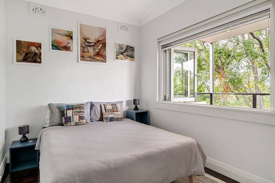 A second bedroom has a queen bed and streams of light coming in through the large, foldable window that looks out to the balcony. Please note that this bedroom does not have air conditioning. However, there is a ceiling fan for your comfort.