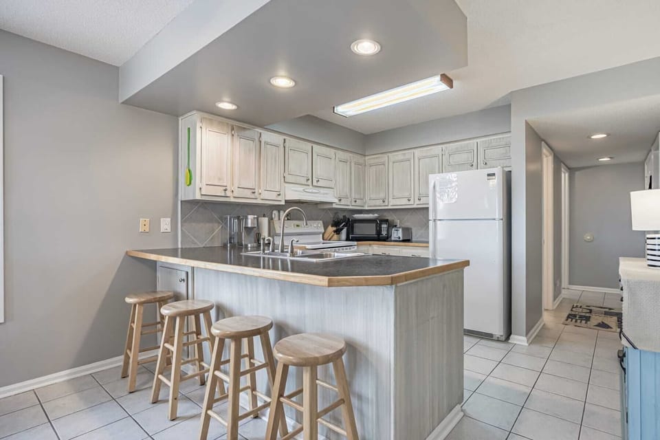 Barstool seating for four at the kitchen counter next to the dining room table