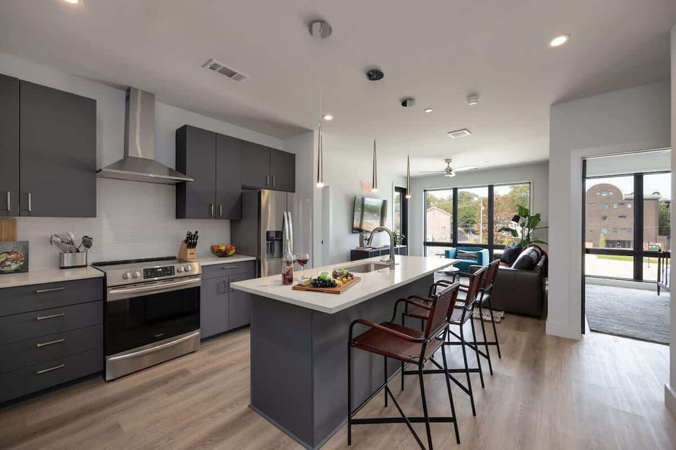 Fully equipped modern kitchen boasting brand-new stainless-steel appliances and stocked with all culinary essentials for ease and convenience. Kitchen island offers ample counter space and bar seating.