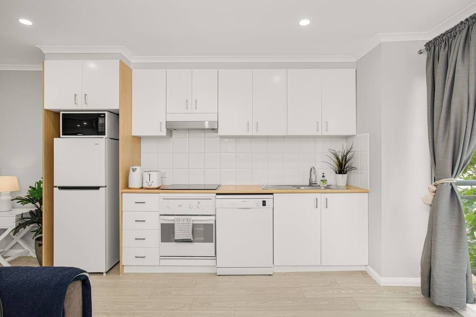 The compact kitchen is well-equipped for meals at home with an oven, stove, microwave and dishwasher.
