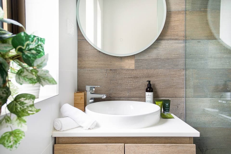 The bathroom is immaculately presented with a shower, toilet and mirrored basin.