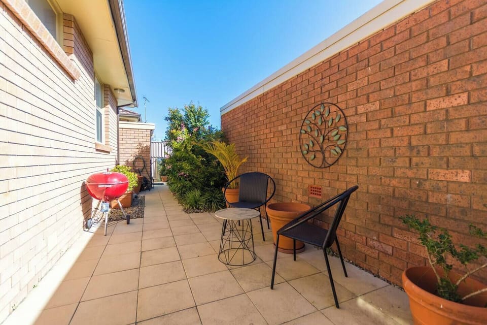 The outdoor patio features seating, a gas BBQ, and dining table (located on the other side). The laundry is located at the back.
