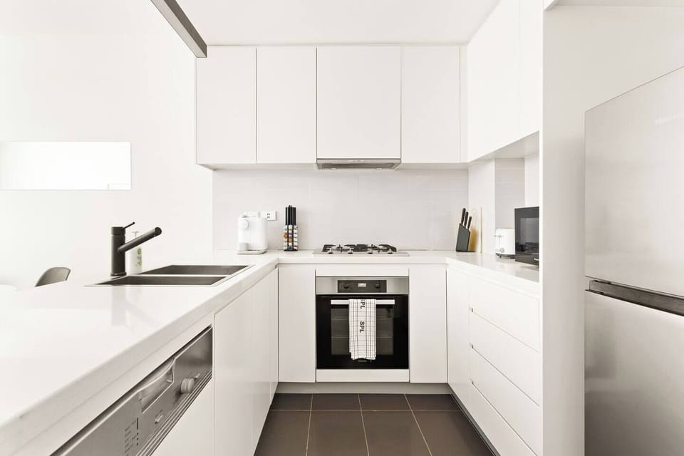 A sleek white kitchen lets guests whip up a feast on top-quality appliances and cooking utensils.
