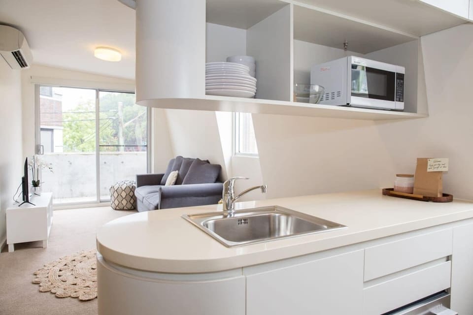 The round kitchen island functions as the heart of the home with open plan living and dining space flowing to the balcony.