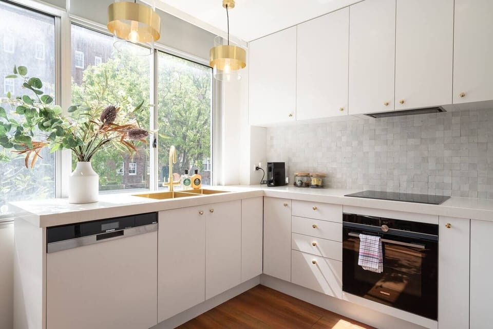 The stylish gourmet kitchen features golden hues and comes fully equipped for meals at home.
