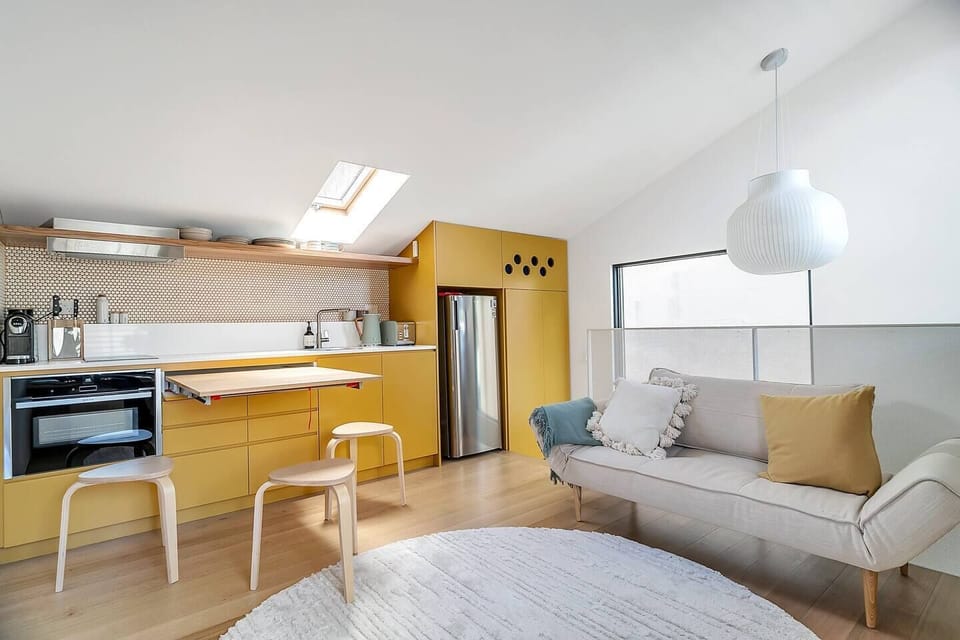 A trendy table rolls out from the kitchen cabinetry, providing a cosy spot to dine at home or work remotely.