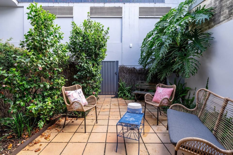 A seating nook within the backyard provides a green sanctuary to sip your morning coffee or unwind with a book.