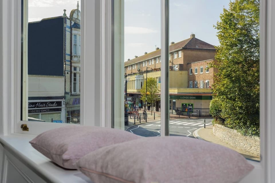 Living Room: Enjoy vibrant street views from plush window seats in this modern haven!