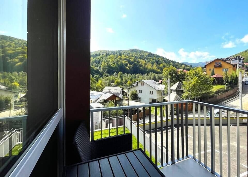 Outdoor balcony with outdoor furniture and mountain panoramic view.