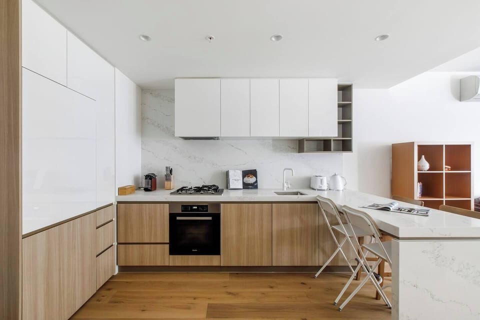 A full kitchen is equipped with sleek appliances and utensils, as well as a breakfast bar.
