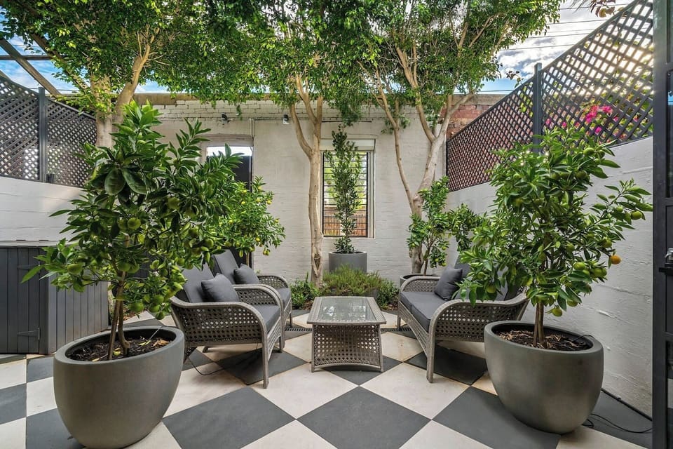Featuring black and white floor tiles and surrounded by greenery, sip your morning coffee in the private courtyard.