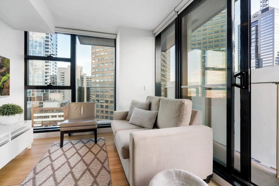 A cosy living area features a flat-screen TV, plush sofa and direct access to the balcony.