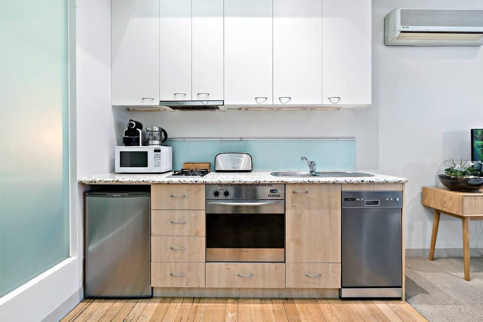 The compact kitchen features all the essentials, plus a dishwasher and Nespresso machine, perfect for longer stays.