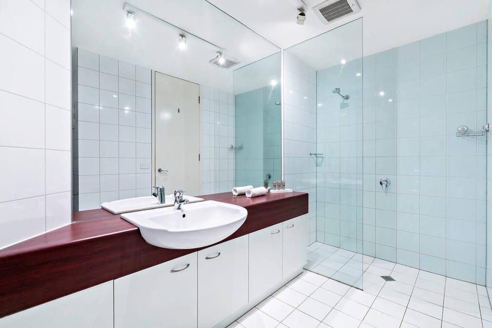 The bathroom features a glass walk-in shower, toilet and oversized vanity.