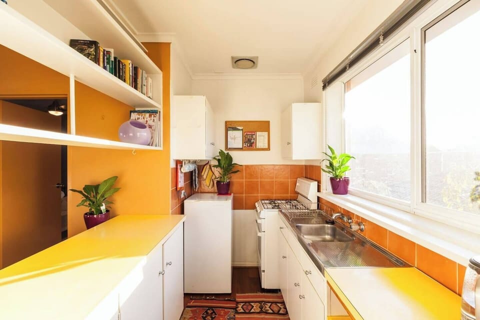 Cook up a storm in this warm, inviting galley-style kitchen, bathed in natural light from the large window. Practical storage solutions keep everything within reach, making it easy to prepare your favorite meals.