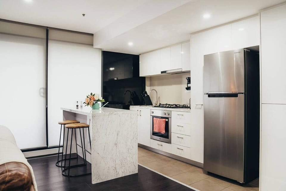 The kitchen is fully-equipped, boasting a a marble island with benchtop seating.