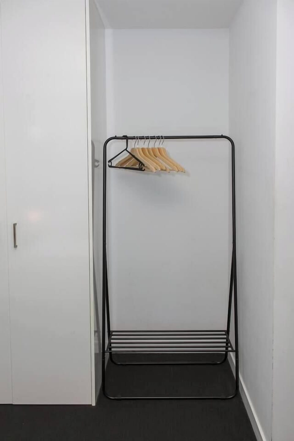 The second bedroom features a convenient clothing rack, ensuring easy organisation during your stay.