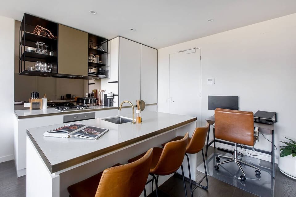 The modern kitchen has all you need to cook meals at home, with seating available at the breakfast bar and a dishwasher for easy clean-up.