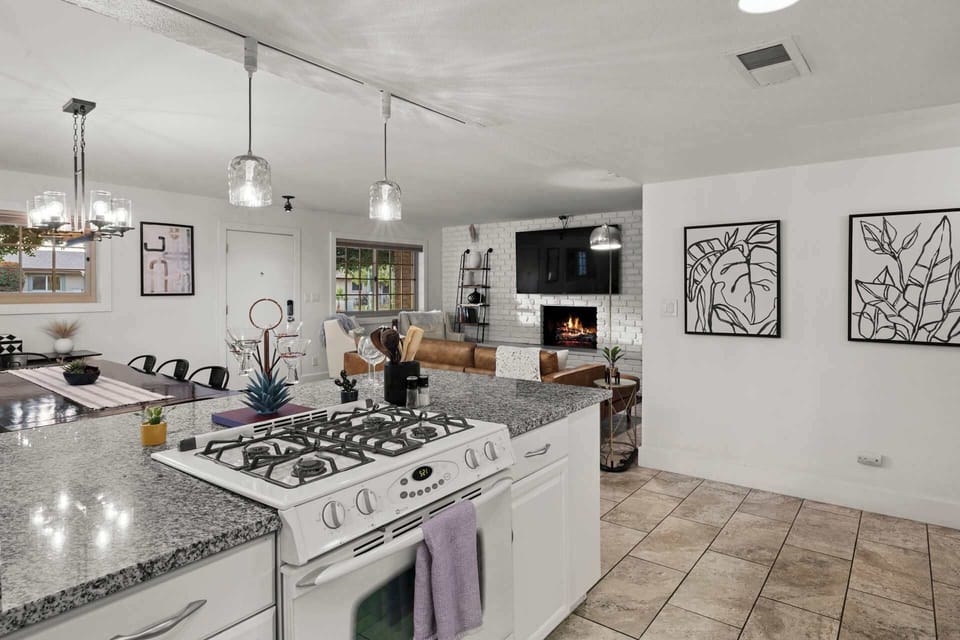Fully stocked kitchen with generous counter space, granite island, and seating for casual bites or cocktails