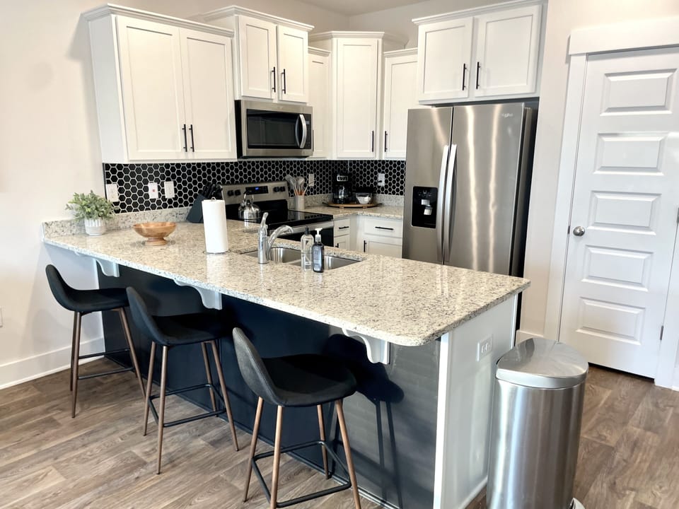 Fabulous Entertaining: Experience the Perfect Blend of Style and Functionality in our Kitchen, Boasting a Spacious Peninsula and Bar Sitting Area, Ideal for Effortless Socializing and Enjoying Culinary Delights in a Modern and Inviting Space.
