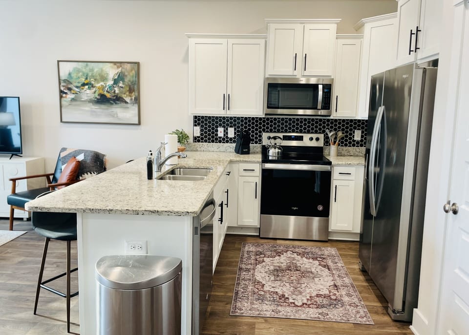 Modern Elegance: Delight in the Upgraded Kitchen with Stylish Backsplash and Sleek Handle Pulls, Enhancing the Contemporary Charm of this New and Inviting Culinary Space.