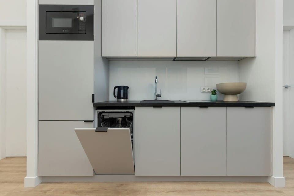 Kitchenette with plenty of kitchen utensils and dishes. 